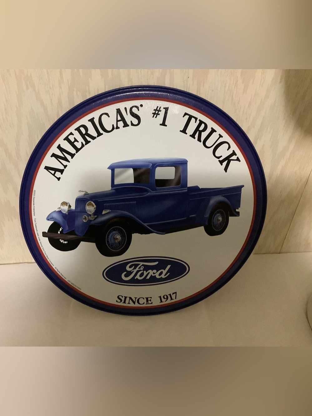 Decorative metal sign featuring a vintage blue Ford pick up truck.